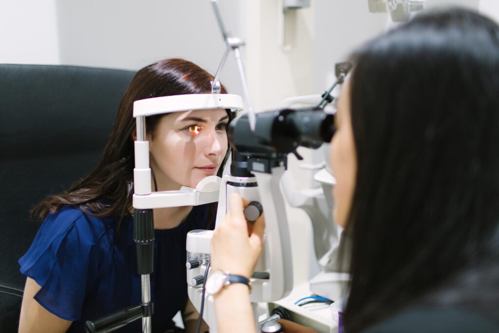 A female optometrist giving a patient an eye scan in an eye test room